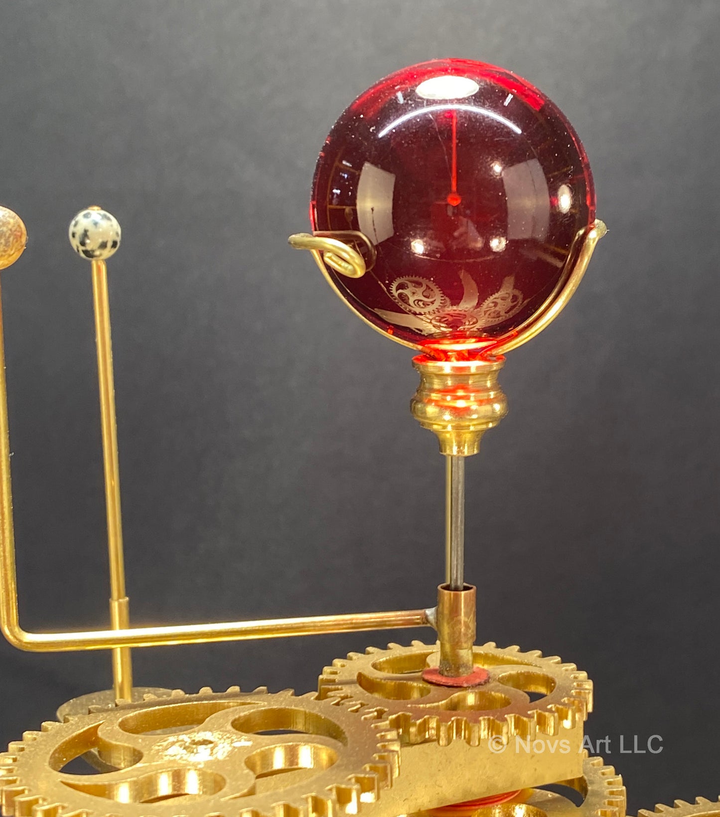 Red glass sphere depicting the dwarf sun of the Trappist-1 solar system orrery.