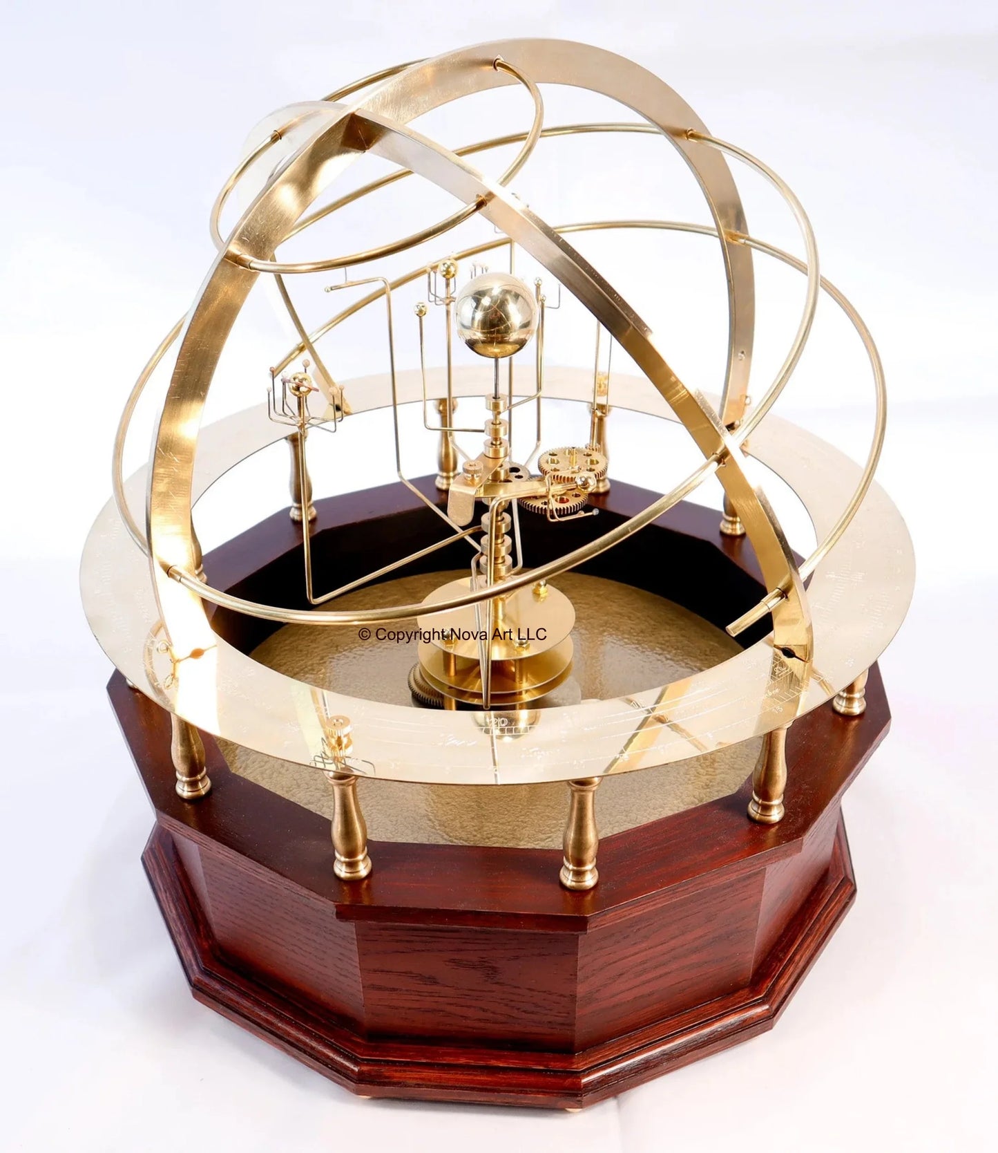 Shows the Grand Orrery in red mahogany hardwood base, brass calendar ring, and half armillary sphere Within the half armillary is shown the brass planets of the solar system with an earth moon system.