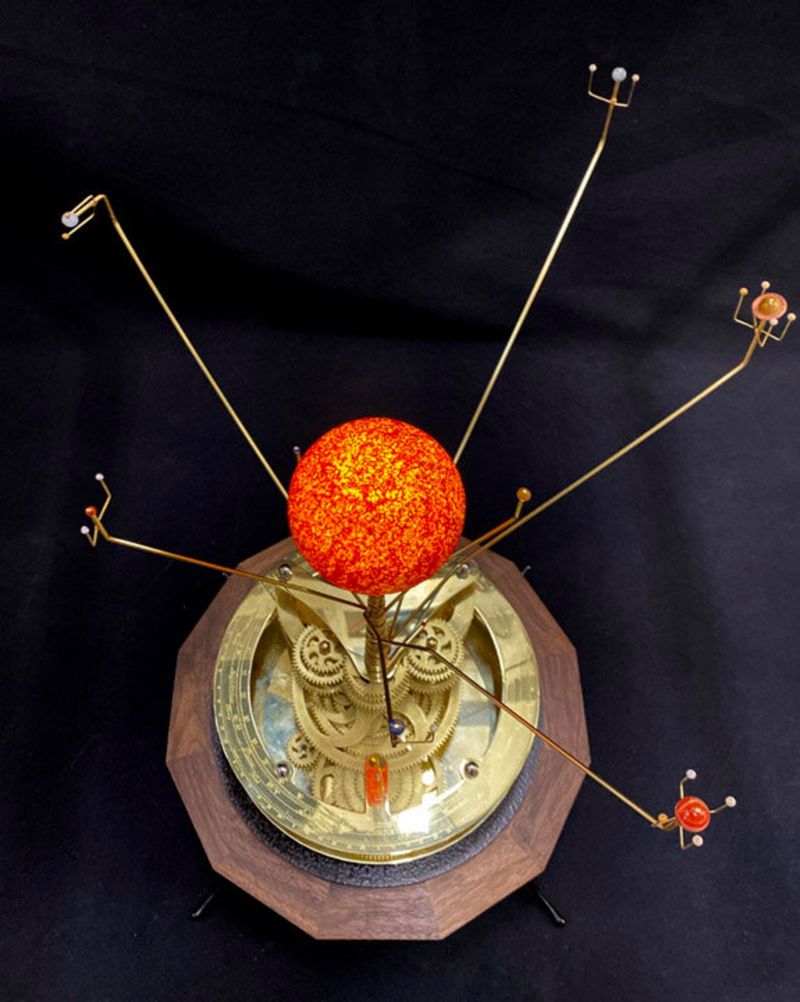 Renaissance Orrery depicting the 8 planets and Sun in correct relative motion. The hand painted Sun and solid brass gearworks sit on a solid walnut base.