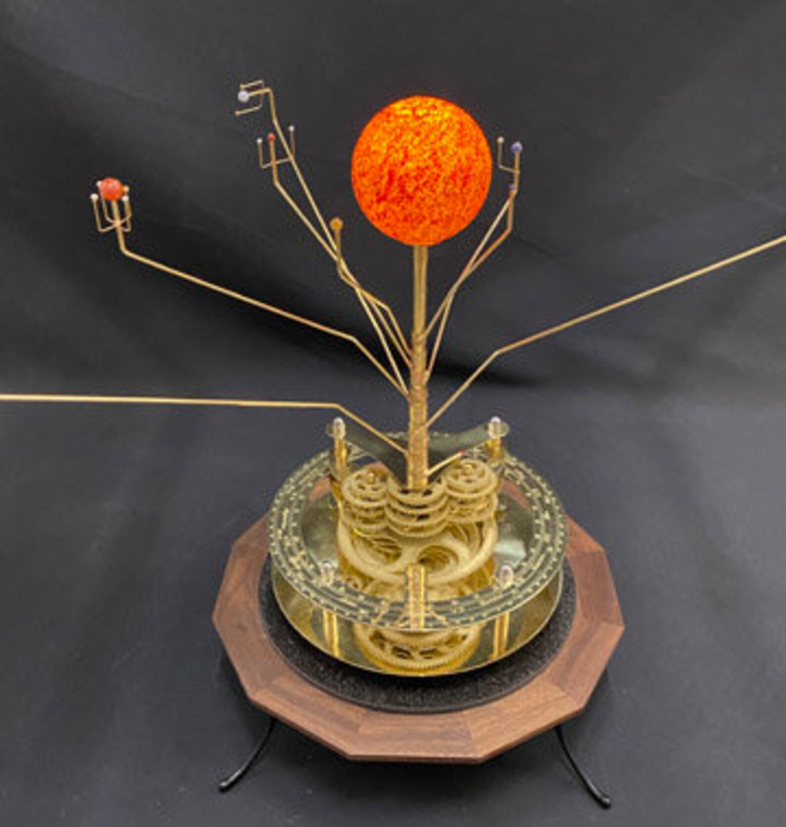 Renaissance Orrery depicting the 8 planets and Sun in correct relative motion. The hand painted Sun and solid brass gearworks sit on a solid walnut base.