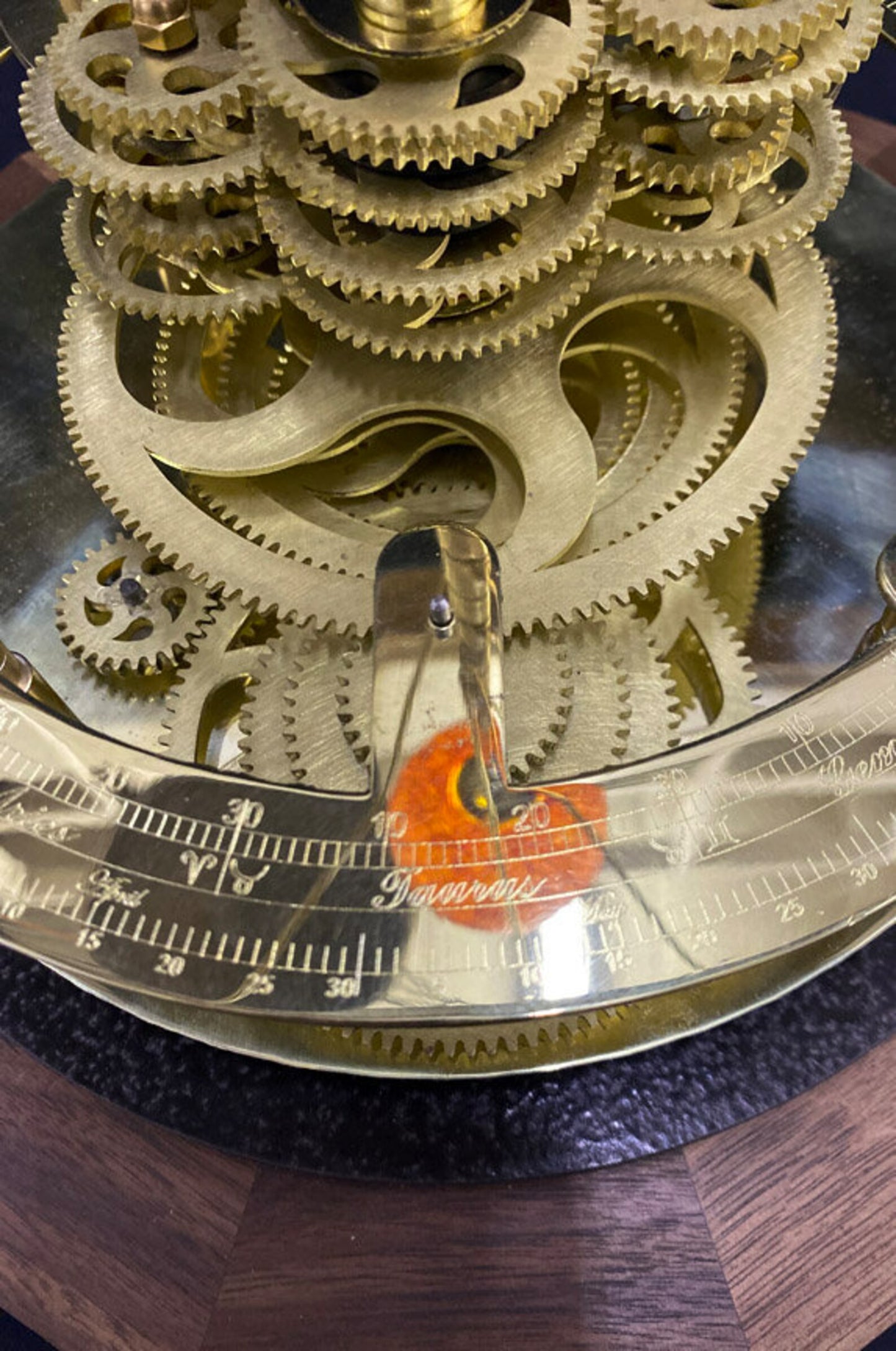 Close up of the solid brass gearworks fo the Renaissance orrery from Science Art. Shows close up of the gearwork mechanism of the orrery, calendar ring and walnut base.